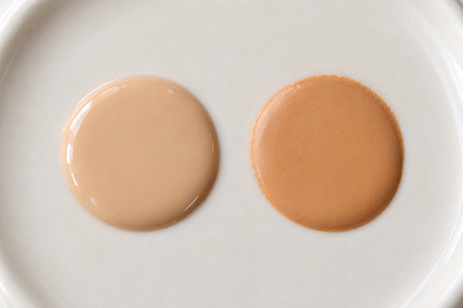 Fresh light beige foundation drop beside a darker, warmer drop after 30 minutes of drying